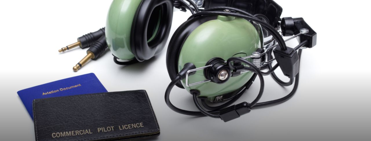 Pilot headset next to pilot's license